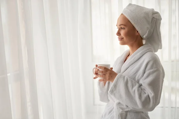 Fille en peignoir tenant tasse avec café . — Photo