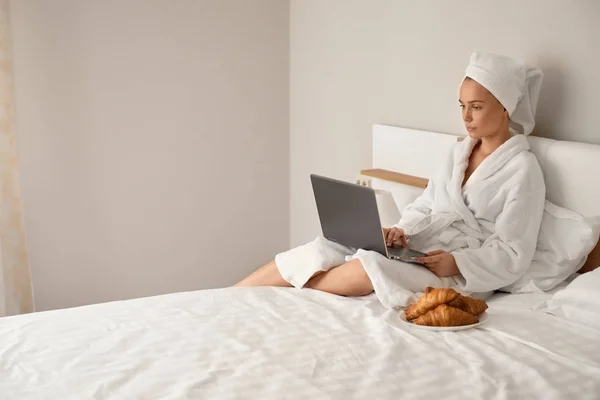 Kvinnan i badrock skriver på laptop. — Stockfoto