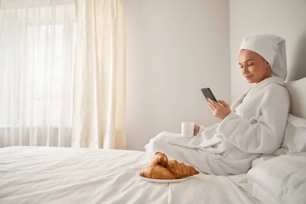 Flicka vakna och använda smartphone. — Stockfoto
