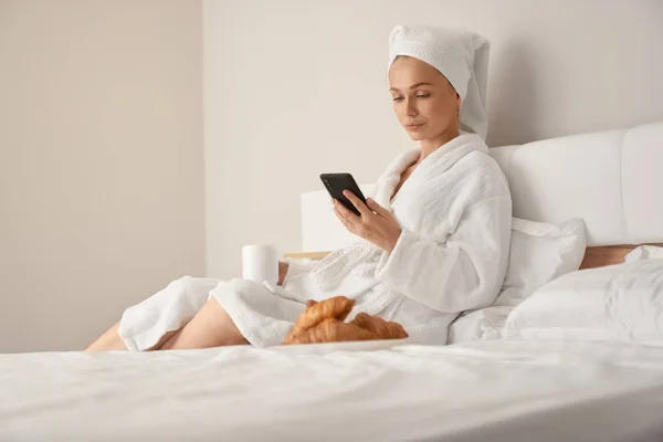 Flicka vakna och använda smartphone. — Stockfoto