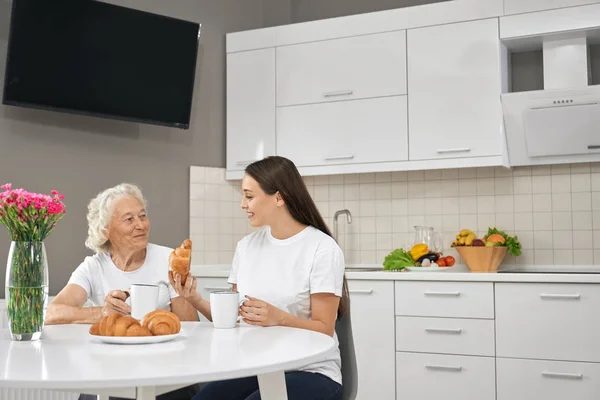 Старшая женщина смеется с внучкой на кухне . — стоковое фото