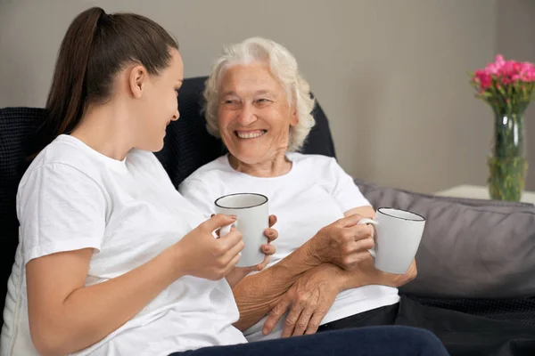 Oudere vrouw in gesprek met kleindochter. — Stockfoto