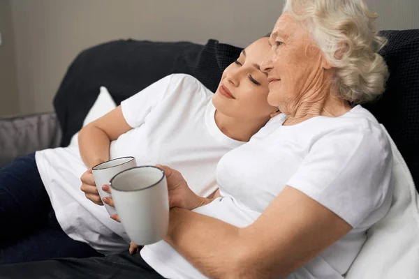 Giovane donna sdraiata sulla spalla della nonna . — Foto Stock