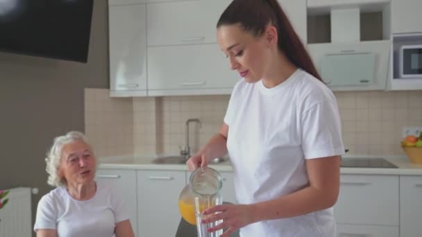 Brunette woman pouring juice into glasses. — 비디오