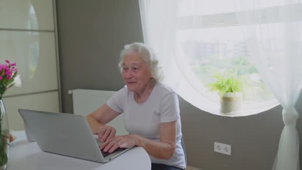 Starsza kobieta ma rozmowę wideo na laptopie. — Wideo stockowe