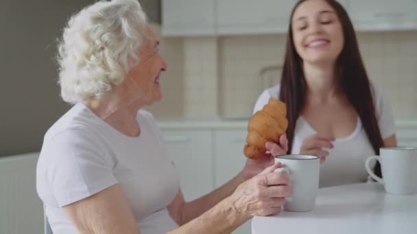 Senior kvinna som erbjuder barnbarn croissant. — Stockvideo