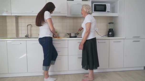 Donna sorridente che aiuta la nonna a cucinare . — Video Stock