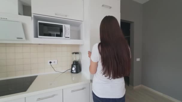 Jonge vrouw die groenten uit de koelkast haalt. — Stockvideo