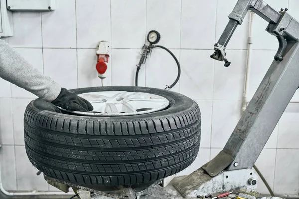 Autotechniker ersetzt alten Reifen am Rad in Garage — Stockfoto