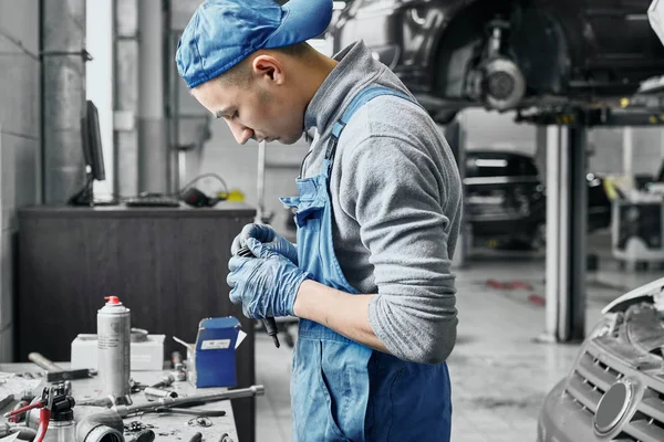 Auto mechanic working near table with different tools — Stock Photo, Image