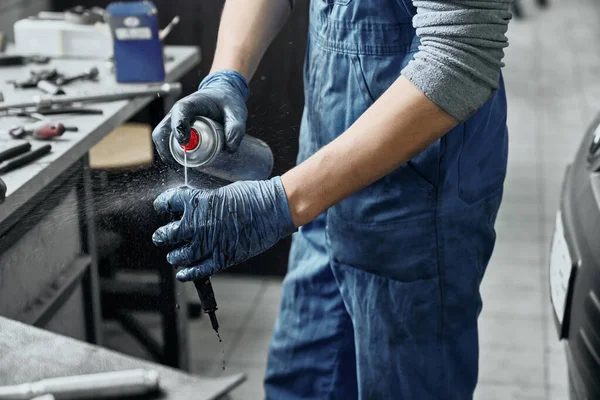 Mechanic spraying substance to remove rust from spark plug — ストック写真