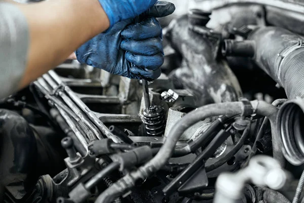 Close up of mans hands tighten bolts in spark plugs — ストック写真