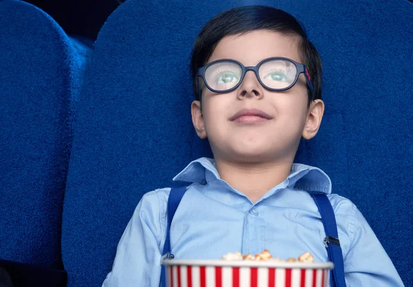 Vista frontal de un niño viendo una película excitada en el cine — Foto de Stock