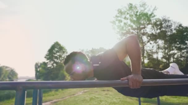 Uomo afro muscolare che esercita su attrezzature sportive all'aperto — Video Stock