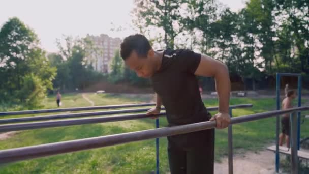 Вид збоку тренування м'язистого африканця на паралельних брусах — стокове відео