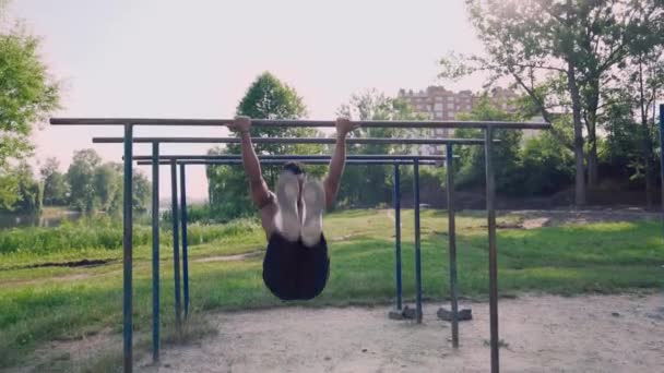 Active afro man doing abdominal exercises on pull up bar — 비디오