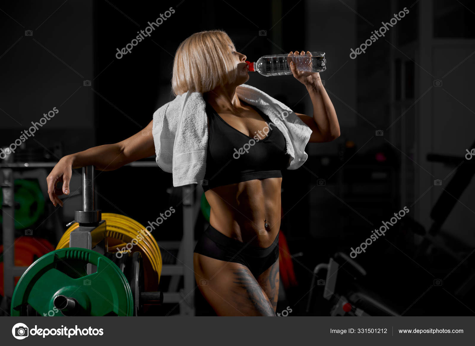 Female bodybuilder drinking water after workout Stock Photo