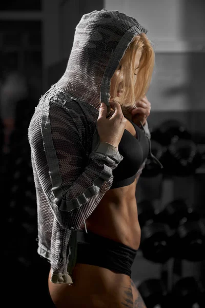Vrouwelijke bodybuilder poseren in de sportschool. — Stockfoto