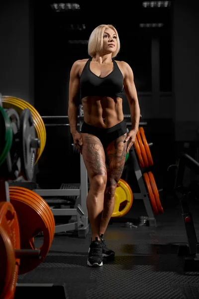 Bodybuilder femminile in posa in palestra. — Foto Stock