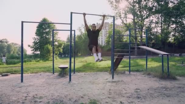 Sterke afro man doet abdominale oefening in groen park — Stockvideo