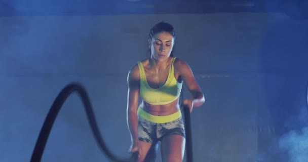 Mulher morena muscular fazendo treinamento de corda de batalha. — Vídeo de Stock