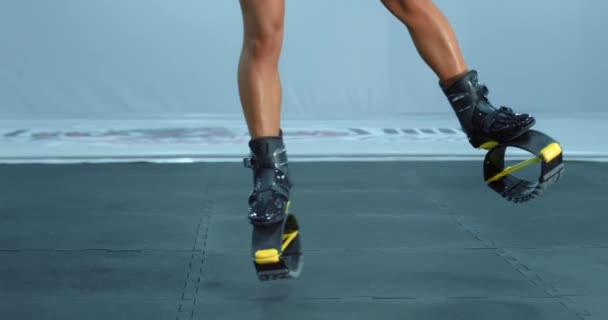 Primer plano de las piernas de la mujer mientras que hace saltos de kangoo . — Vídeos de Stock