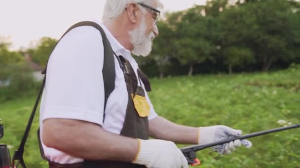 Зрілий чоловік пестициди картопляні кущі з жуків колорадо — стокове відео