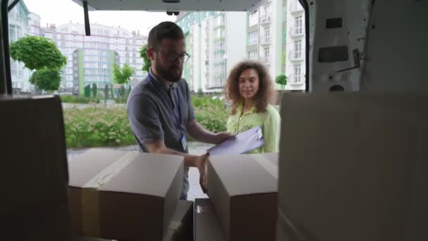 Levering man het geven van pakket naar gelukkig vrouwelijke klant outdoor — Stockvideo