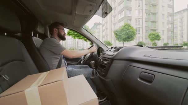 Joven mensajero masculino que conduce el coche del servicio de entrega con los paquetes — Vídeo de stock
