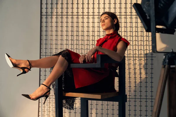 Kırmızılı kadın stüdyoda sandalyede oturuyor.. — Stok fotoğraf