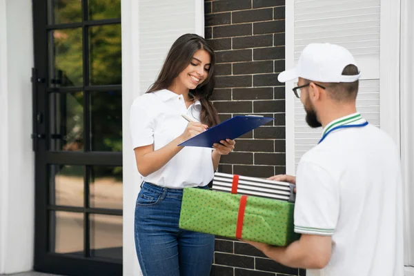 Vrouw die papier ondertekent en dozen ontvangt. — Stockfoto