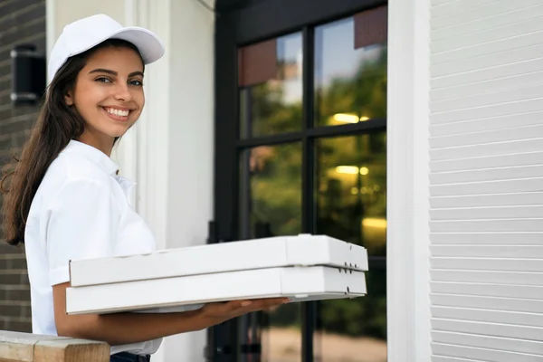 Glimlachende bezorger met dozen pizza. — Stockfoto