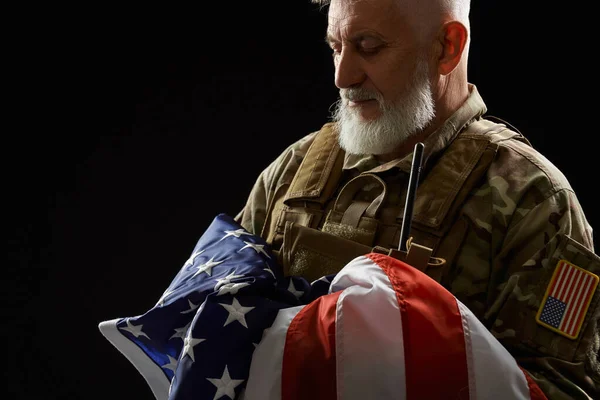 Veterano de uniforme militar segurando bandeira americana . — Fotografia de Stock