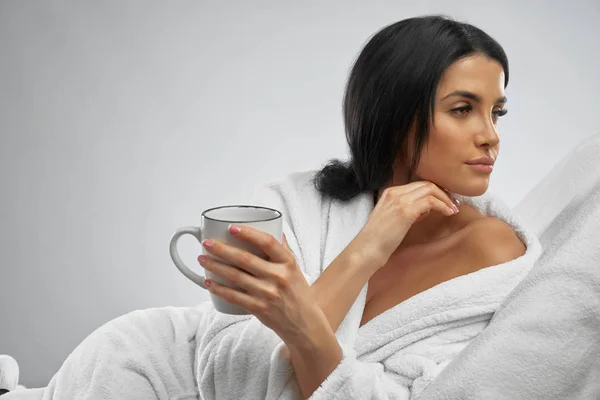 Brunette in bathrobe drinking morning coffee. — Stock Photo, Image