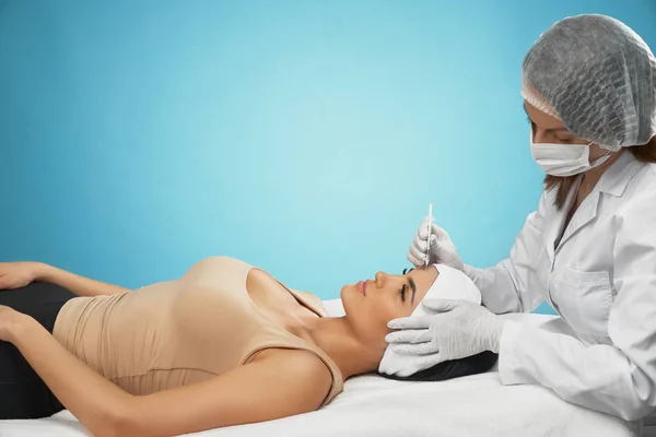 Cosmetische botox injectie in het voorhoofd van de vrouw. — Stockfoto