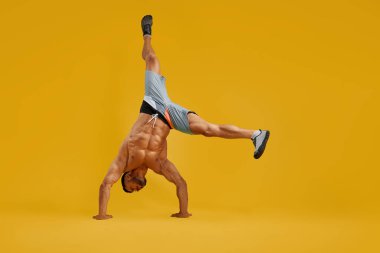 Güçlü genç adam amuda kalkma egzersizi yapıyor.