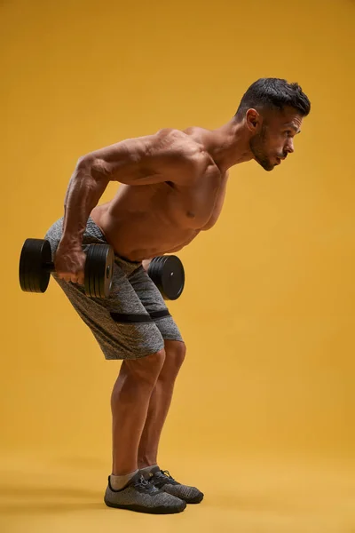 Homme athlétique torse nu faisant de l'exercice avec des haltères — Photo