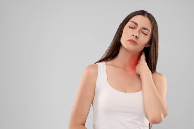 Kadın acıdan boynuna dokunuyor..