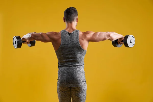 Muscular strong man doing exercise with dumbbells — Stock Photo, Image