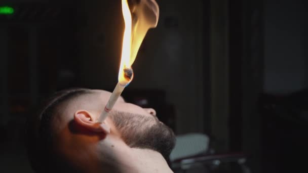Cliente haciendo depilación de orejas con técnica de quemado — Vídeos de Stock