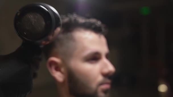 Side view of young man getting groomed with hair dryer — Stock Video