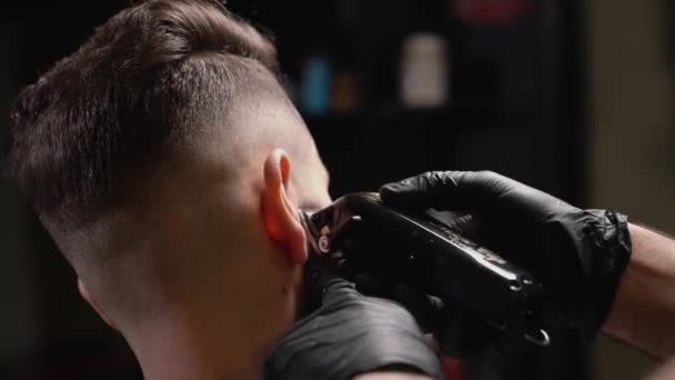 Красивий чоловік отримує нову зачіску з електричним тримером — стокове відео