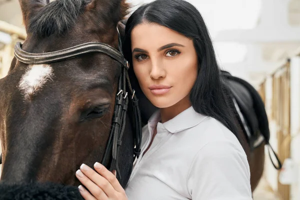 Wanita muda yang menawan memeluk kuda ras yang indah — Stok Foto