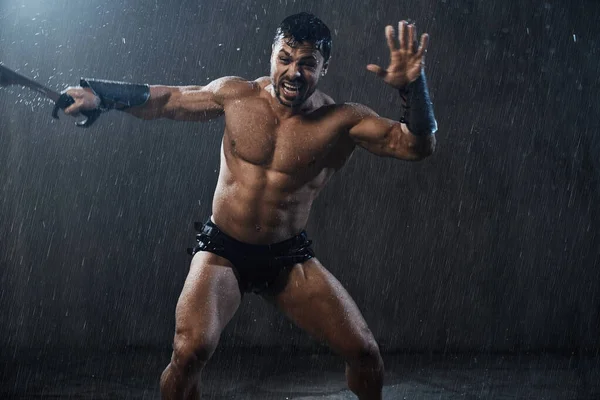 Guerrero húmedo sin camisa luchando con espada . — Foto de Stock