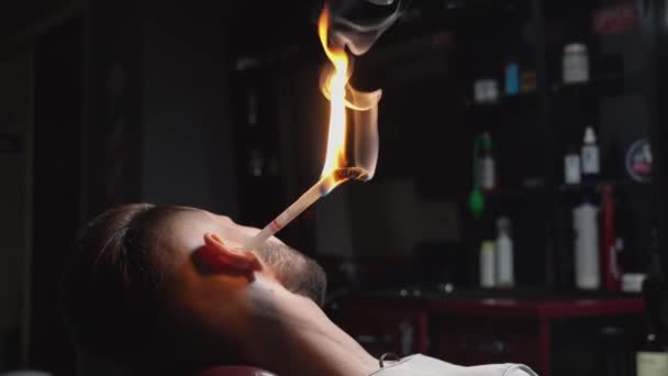 Szakállas ügyfél kap haj tűz kezelés a fodrászatban — Stock videók