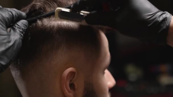 Peluquero profesional haciendo corte de pelo de hombre barbudo guapo — Vídeos de Stock