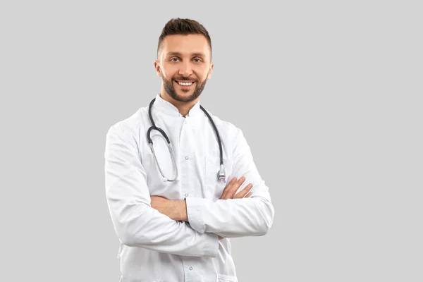 Usmívající se lékař se strethoskopem izolovaným na šedi. — Stock fotografie