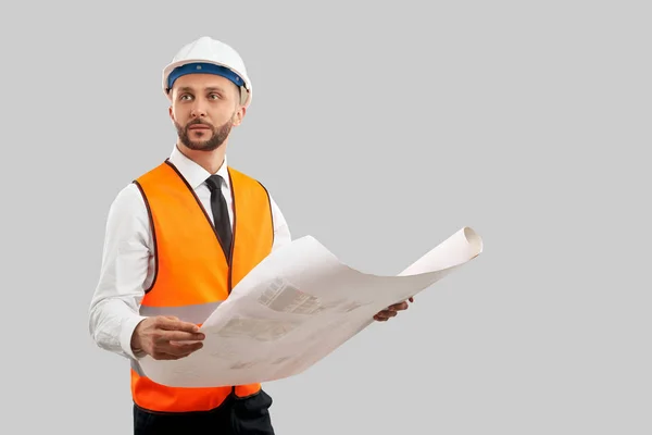 Architect in reflective vest holding construction plan. — Stock Photo, Image