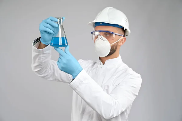Химик в маске держит фляжку . — стоковое фото