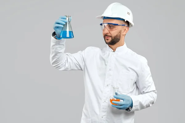 Химик держит фляжки с жидкостью . — стоковое фото